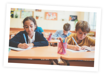 Children at a desk writing