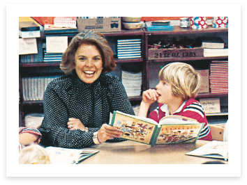 Woman and a child sitting at a desk reading