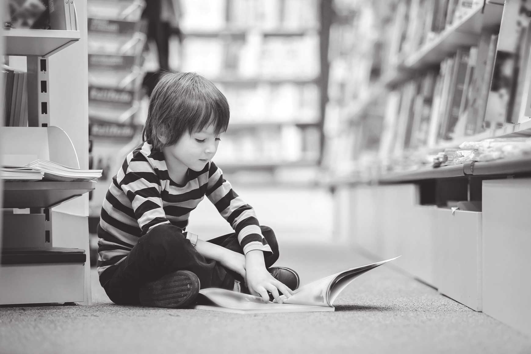 Boy reading book on the floor