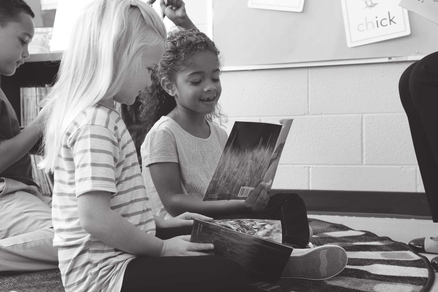 Children reading a book together