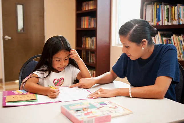 Teacher assists student with word study using Superkids Foundational Skills Kit materials