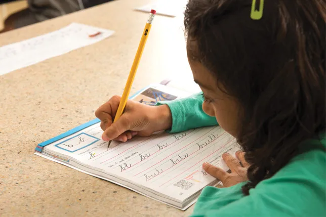 Student at desk practices handwriting in Zaner-Bloser Handwriting Student Edition