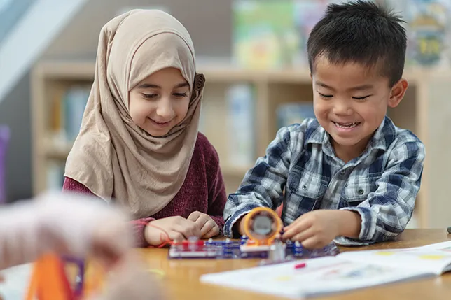 Two students collaborating with hands-on learning materials