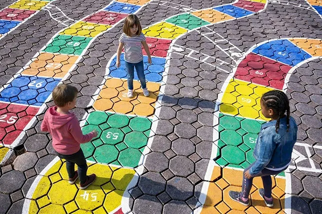 Three students explore a giant number line painted on playground