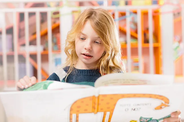 Student reading a picture book independently